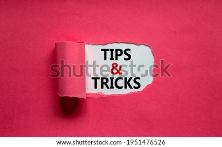 Tips and tricks symbol. Words 'Tips and tricks' appearing behind torn orange paper. Beautiful purple background. Business, Tips and tricks concept. Copy space. Royalty-Free Stock Photo #1951476526
