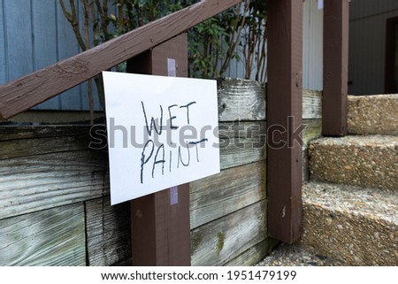 A wet paint sign on a fence