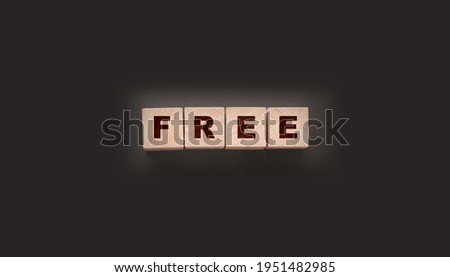 the word free on wooden blocks on black background. Business concept.