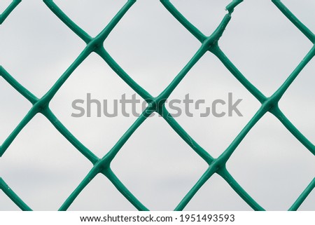 mesh green plastic fence against the sky