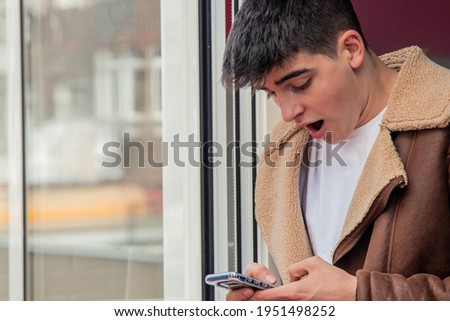 amazed young man looking at mobile phone