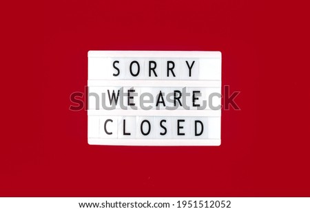 Sorry we are closed sign, lightbox with text message on a red background, top view photo