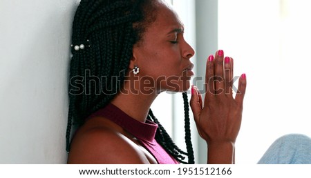 Black woman praying to God, african female raising arms to sky seeking guidance