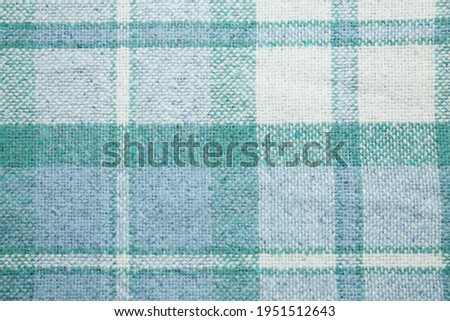 Turquoise woolen fabric with geometrical pattern as background, top view