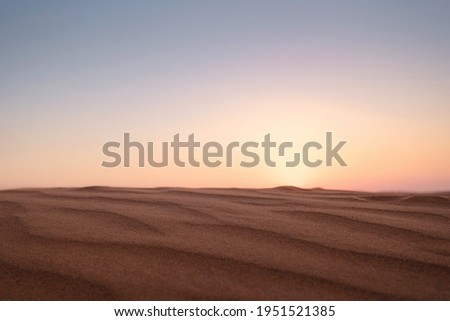 Sunset over the sand dunes in the desert. The ghost town of Al-Madam is about 60 km from Dubai City. united arab emirates. The concept of global warming