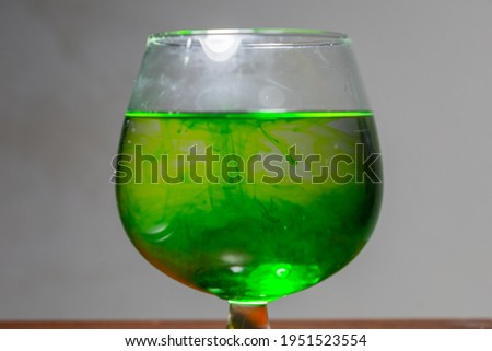 Add food coloring to the oil and water in a wine glass.