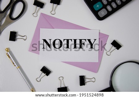 notify word written on pink envelope near office supplies. word Royalty-Free Stock Photo #1951524898