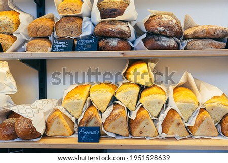 Close-up photo of various bakery products wrapped in a paper wrapper on the shelves of a bakery store