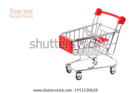 Empty grocery shopping cart. Miniature empty red color shopping cart or trolley isolated on white background . There is some free space for your text or sign.