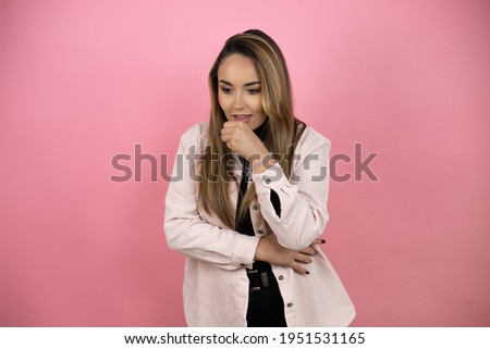Young beautiful blonde woman with long hair standing over pink background coughing with the hand next to the mouth