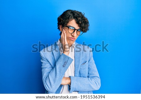Hispanic young man wearing business jacket and glasses thinking looking tired and bored with depression problems with crossed arms. 