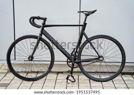 Black city bicycle against grey wall in the city