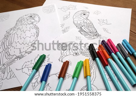 Drawings for coloring and felt tip pens on table