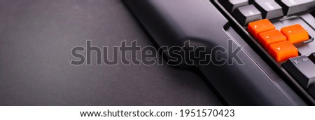 Orange arrow keys on a black keyboard, up, down, left, right buttons on a gaming computer keyboard.