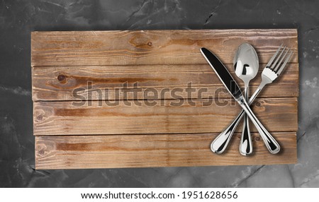 Cutlery set on dark wooden board