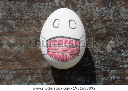 egg on wood with a red painted mask