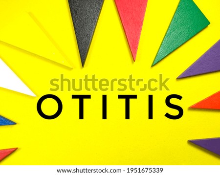 Medical concept.Colorful pieces of wood on yellow background with text OTITIS