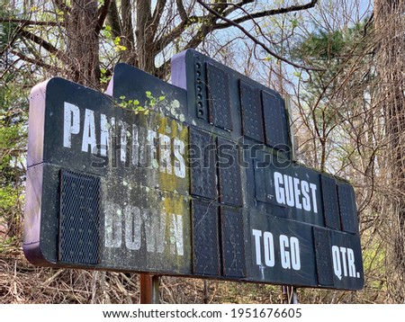 Abandoned and decaying score board in the woods with mold, moss and lichen in a forest
