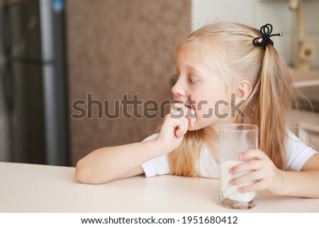 beautiful cute little caucasian child 6years old girl drinking delicious organic whole grain milk with vitamins calcium from glass. Young children enjoy delicious and nutritious lactose-free yoghurt. 