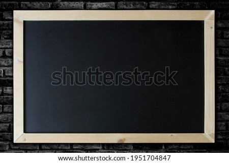 Blackboard background and wooden frame on brick wall background.
