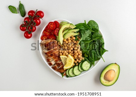 Dietary salad with chicken, avocado, cucumber, tomato and spinach on white background. Flat lay
