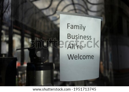 Closeup of a welcome sign on the storefront window of a family-owned coffee shop.