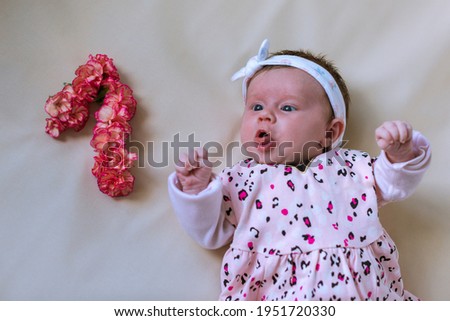 Toddler girl. Newborn. Lying down. Emotions. Top view. Bouquet of flowers. Floral number.