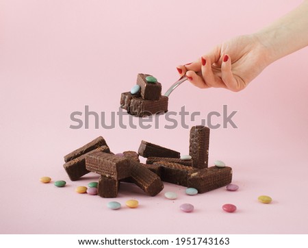 Chocolate cookies and colorful candies arranged on a table prepared for eating with spoon