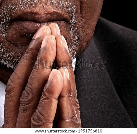 man praying in church with hands together stock photo