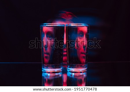 man looking through glass glasses of water with reflections and distortions