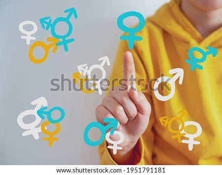 Teen problem Family issues Gender confusion in teenager.  A teen boy pointing at gender symbols of male bigender and transgender. Concept of choice gender confusion or dysphoria. 