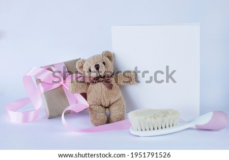 Greeting card for baby girl birth with teddy bear, present and baby hair brush on white background. Image with copy space