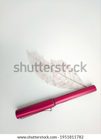 A pink color pen with skeleton leaf isolated on white background.