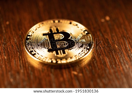 Gold Bitcoin shining on Wood surface. Crypto currency BTC. Concept of Crypto and Block chain technology. New Digital money Bitcoin and Ethereum.