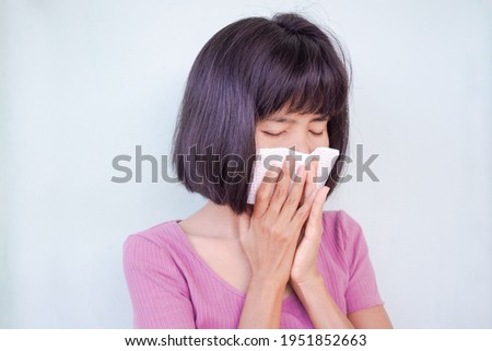 Asian woman have a cold. she is sneezing into handkerchief. sick 
from virus problem. authentic black hair, skin tan and slim shape. health care concept.