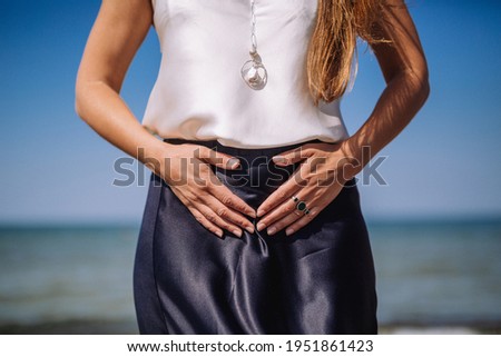 Feminine power. Woman holding hands on womb. Self care and self love. Feminine energy. Female practises.Woman on a beach.  Royalty-Free Stock Photo #1951861423