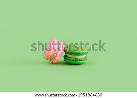 Tasty french macarons on a green pastel background. Place for text.