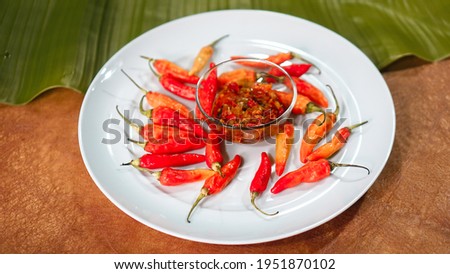 hot chilies on a white plate on a wooden table. photo stock