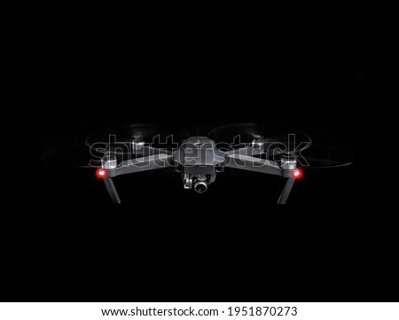 Drone spy. Drone - Flying in the dark, on black background. Closeup on dark. Portable drones, View on the drones gimbal and camera. Royalty-Free Stock Photo #1951870273