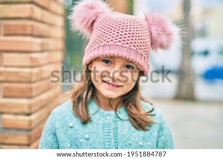 Adorable caucasian child girl smiling happy standing at the city.