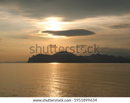 Beautiful golden sunset over the sea and mountains. High quality photo