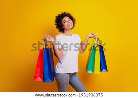 Close up photo beautiful girl carry shopping bags posing on yellow background