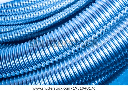 Flexible stainless steel pipes. Pipes for protecting electrical wires. Background made of corrugated bushings for electrical cables. Bushing for laying wires.