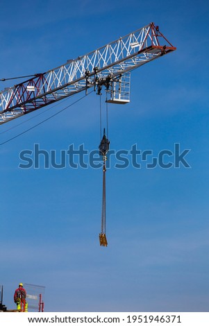 Workers working at height on the construction of a public facility. Collection of structural elements from the construction crane sling. Photo taken on a sunny day. Grodzisk Mazowiecki, Poland