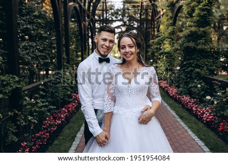 Walk of the bride and groom in the greenhouse. Beautiful summer photo session in nature.