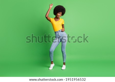 Full size photo of young beautiful smiling cheerful afro woman dancing enjoying weekend isolated on green color background