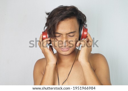 Cool handsome boy listening music at headphones , enjoy music .