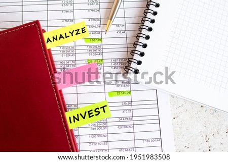A business diary with colored tabs with inscriptions lies on financial charts on the office desk.