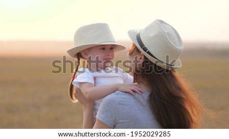 Happy little daughter loves mom, child and mother hug in park. Mom and baby hug. Happy family, mom and daughter in field play on grass. concept of happy family and healthy children. Baby loves mommy