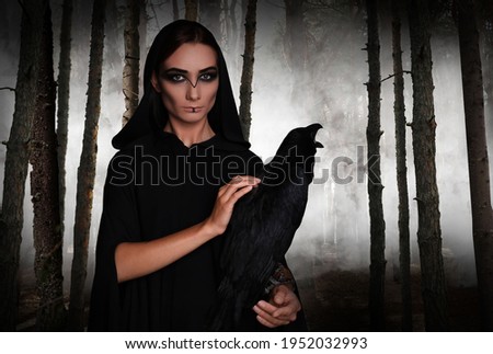Mysterious witch with raven  in foggy forest. Fantasy world